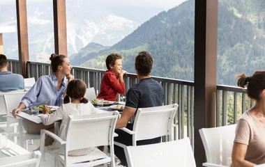 Família no restaurante com vista para as montanhas.