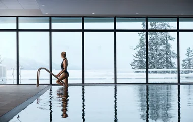 Mulher saindo da piscina do resort Les Arcs Panorama.
