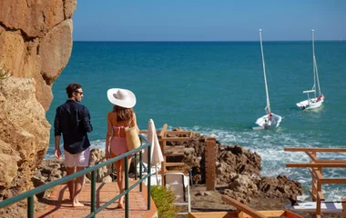 Casal caminhando em direção a praia.