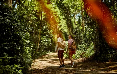 Casal caminhando em trilha.