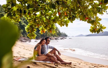 casal abraçado em frente ao mar