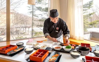 Chefe montando pratos de culinária japonesa.