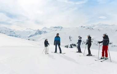 Grupo pratica ski em meio a imensidão da neve dos alpes