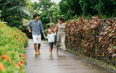 Familia caminhando entre vegetação.