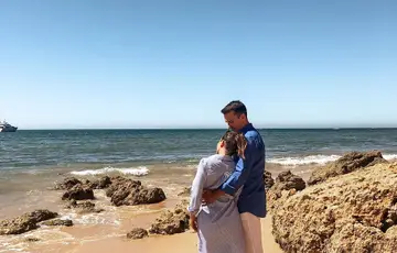 Casal abraçado na praia.