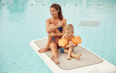 Niño y mujer en la piscina.