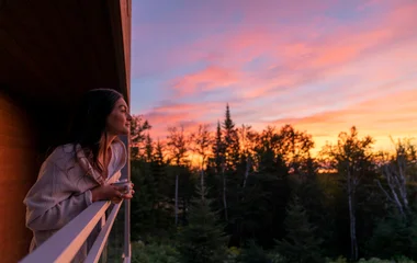Hóspede admirando a vista do Club Med Quebec Charlevoix durante o pôr do sol.