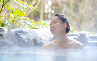 Mujer sonriendo en el agua termal.