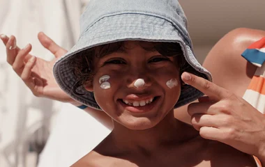 Jeune garçon avec crème solaire