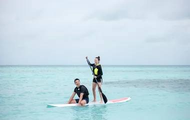 Hombre y mujer practicando stand up paddle.