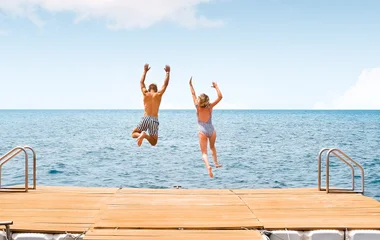 Pareja saltando al mar.