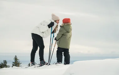 mãe e filho se divertindo na neve