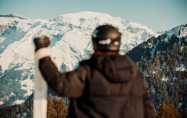 Snowboarder descendo pista nevada em estação de esqui europeia