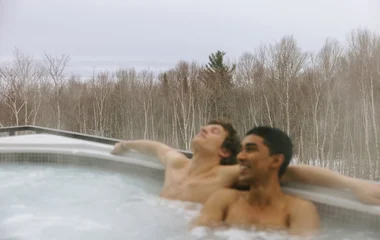 Pareja en la piscina climatizada en paisaje de nieve.