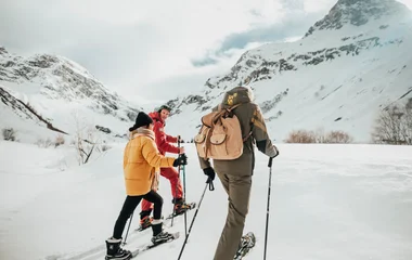Tres personas caminando por la nieve.
