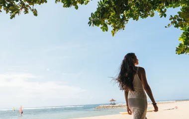 Mulher caminhando na praia.