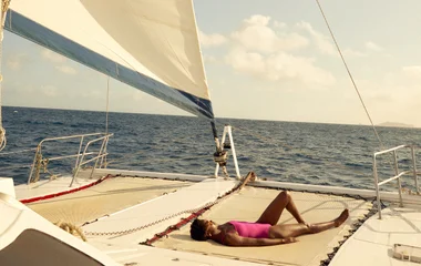 Femme se prélassant sur un catamaran