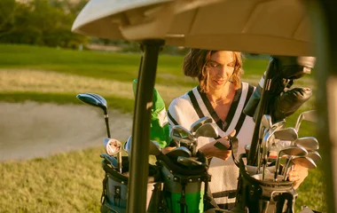 Femme derrière une voiturette de golf
