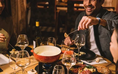 Família jantando em ambiente acolhedor de montanha.