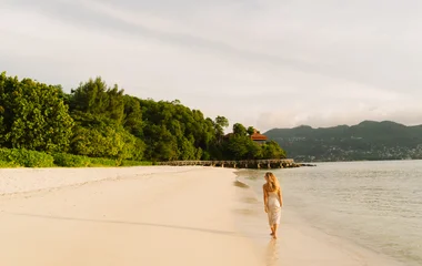 Femme au bord de la plage aux Seychelles