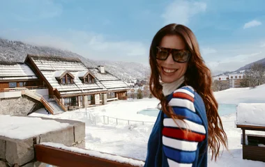Mujer sonriendo en un paisaje nevado.