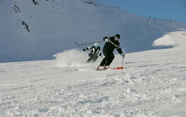 Esquiadores descendo uma montanha de neve.