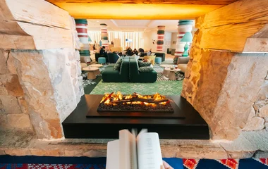 Une personne qui lit devant une cheminée à Serre Chevalier