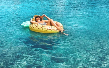 Femme avec un chapeau sur une bouée dans les eaux pures de Kvarner en Croatie