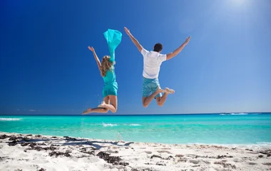 Couple qui saute sur une plage