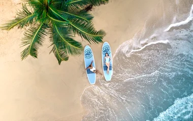 playa con pareja en tablas de surf