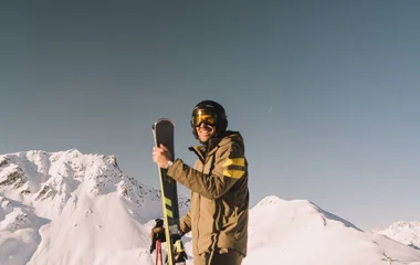 hombre en la montaña con los equipos de ski