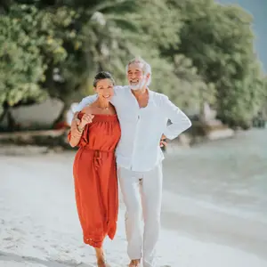 pareja seniors caminando por la playa
