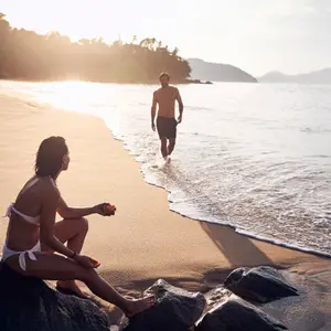 Homem caminhando em direção a mulher na praia.