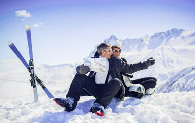 Casal sentado na neve.