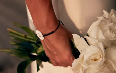 Mulher segurando um buquê de flores brancas.