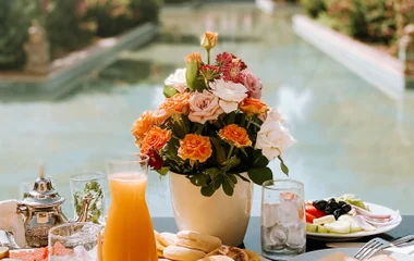 Mesa de café da manhã, com uma vaso de flor natureza ao fundo