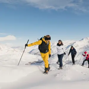 Grupo de pessoas caminhando na neve.