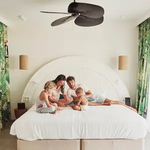 Mãe, pai e filhos na cama.