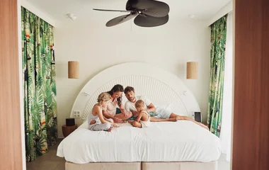 Familia en la cama en la suite del resort.