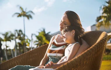 Mãe e filha sentadas no lado externo do resort Club Med Lake Paradise.