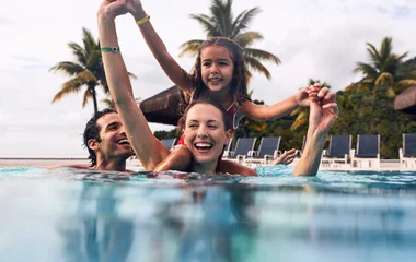 Mãe, pai e filha na piscina do resort Rio das Pedras.