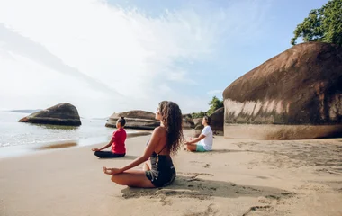 Grupo practicando yoga en la playa.