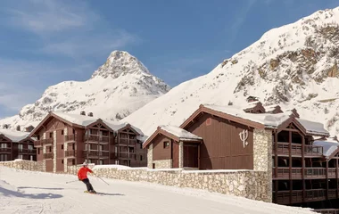 Pessoa esquiando em frente resort do Club Med.