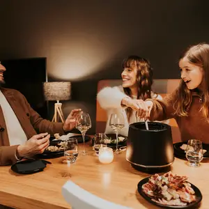 Pai, mãe e filha em jantar com fondue.