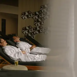 Um homem e uma mulher, de roupão sentados em cadeiras de SPA