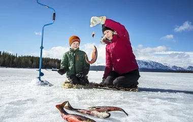 Homem e mulher pescando no gelo.