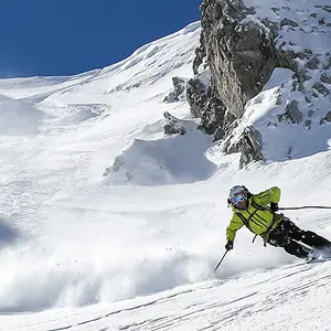 Homem esquiando em dia de sol.