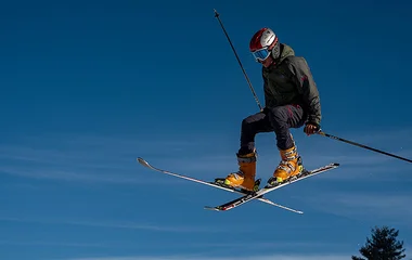 Homem saltando na neve.