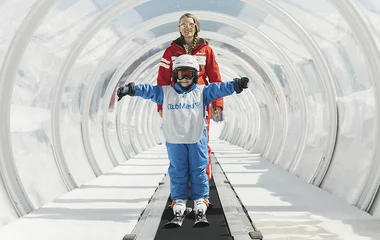 Criança na esteira da estação de esqui com roupa do Club Med.