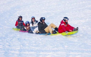 Grupo de pessoas em tobogã na neve.